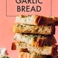 Slices of vegan garlic bread stacked on a plate