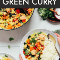 Hands holding a bowl of easy 1-pot salmon green curry with jasmine rice