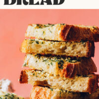 Stack of slices of garlic bread with text above it saying The BEST Vegan Garlic Bread just 7 ingredients