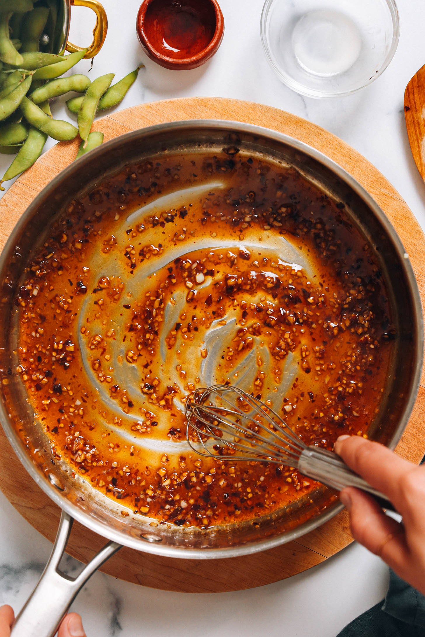 Whisking chili garlic sauce in a skillet