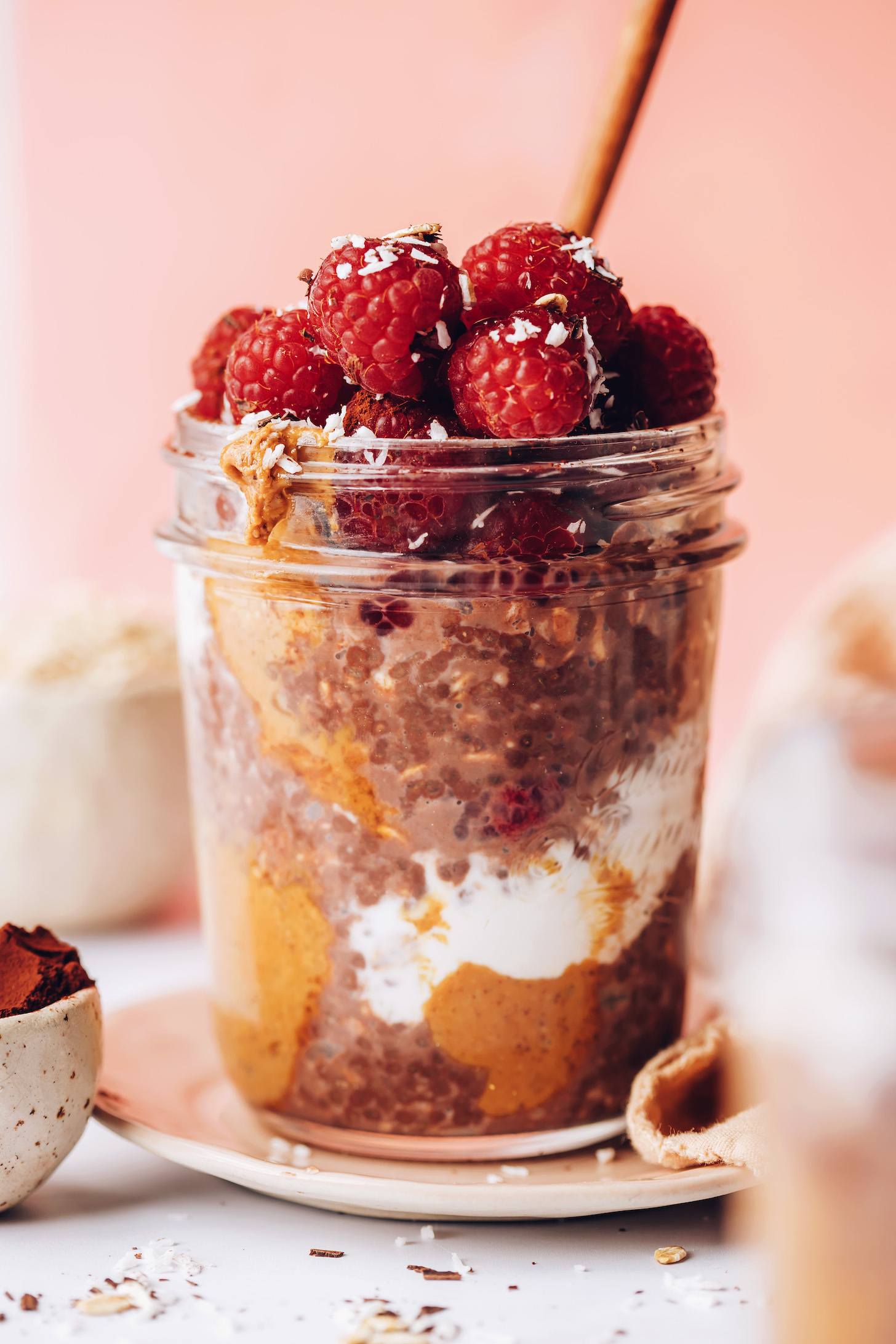 Jar of chocolate overnight oats topped with fresh raspberries