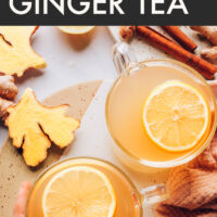 Mugs of fresh ginger tea with lemon slices on top