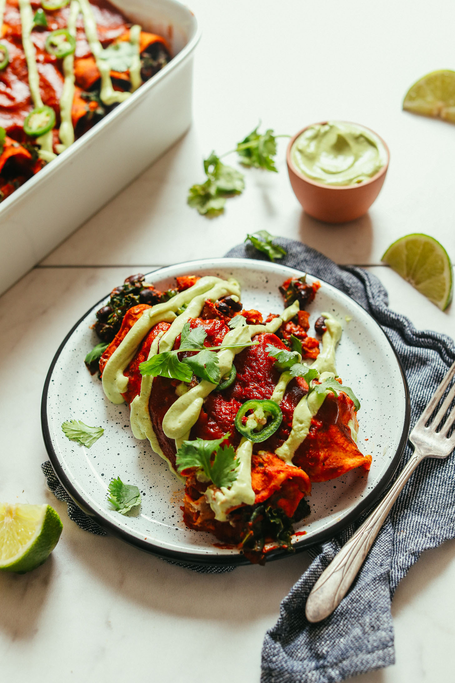 Avocado crema drizzled over enchiladas