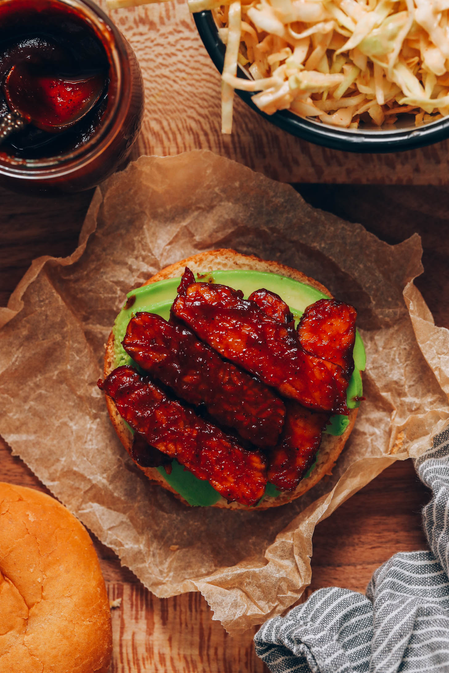 Sliced avocado and BBQ tempeh slices on a bun
