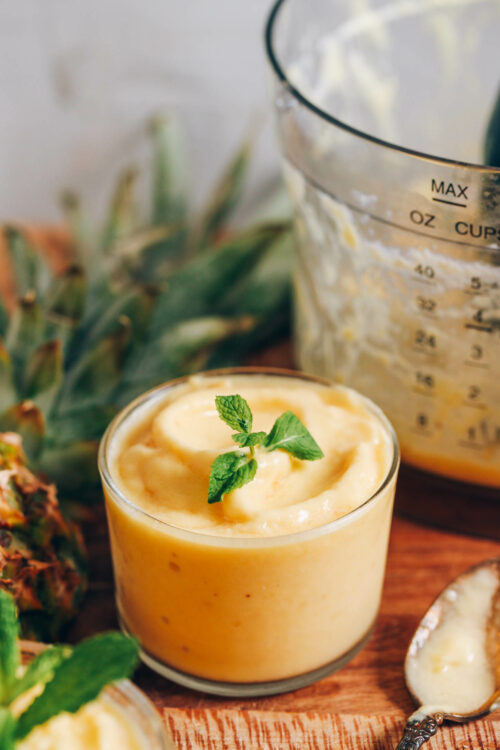 Jar of pineapple sorbet topped with fresh mint leaves