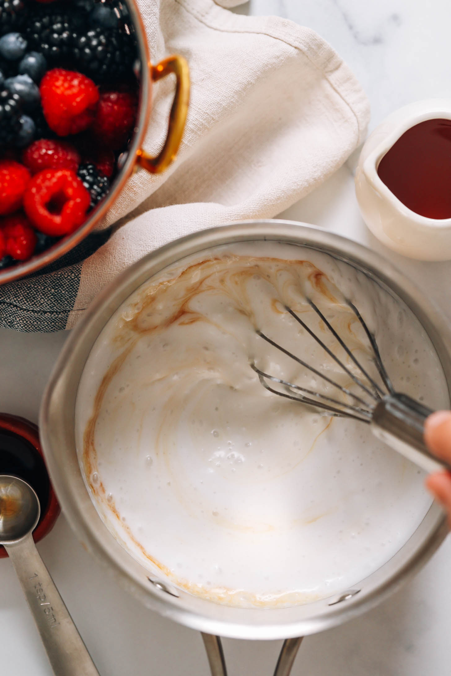 Whisking coconut milk, maple syrup, vanilla, and salt