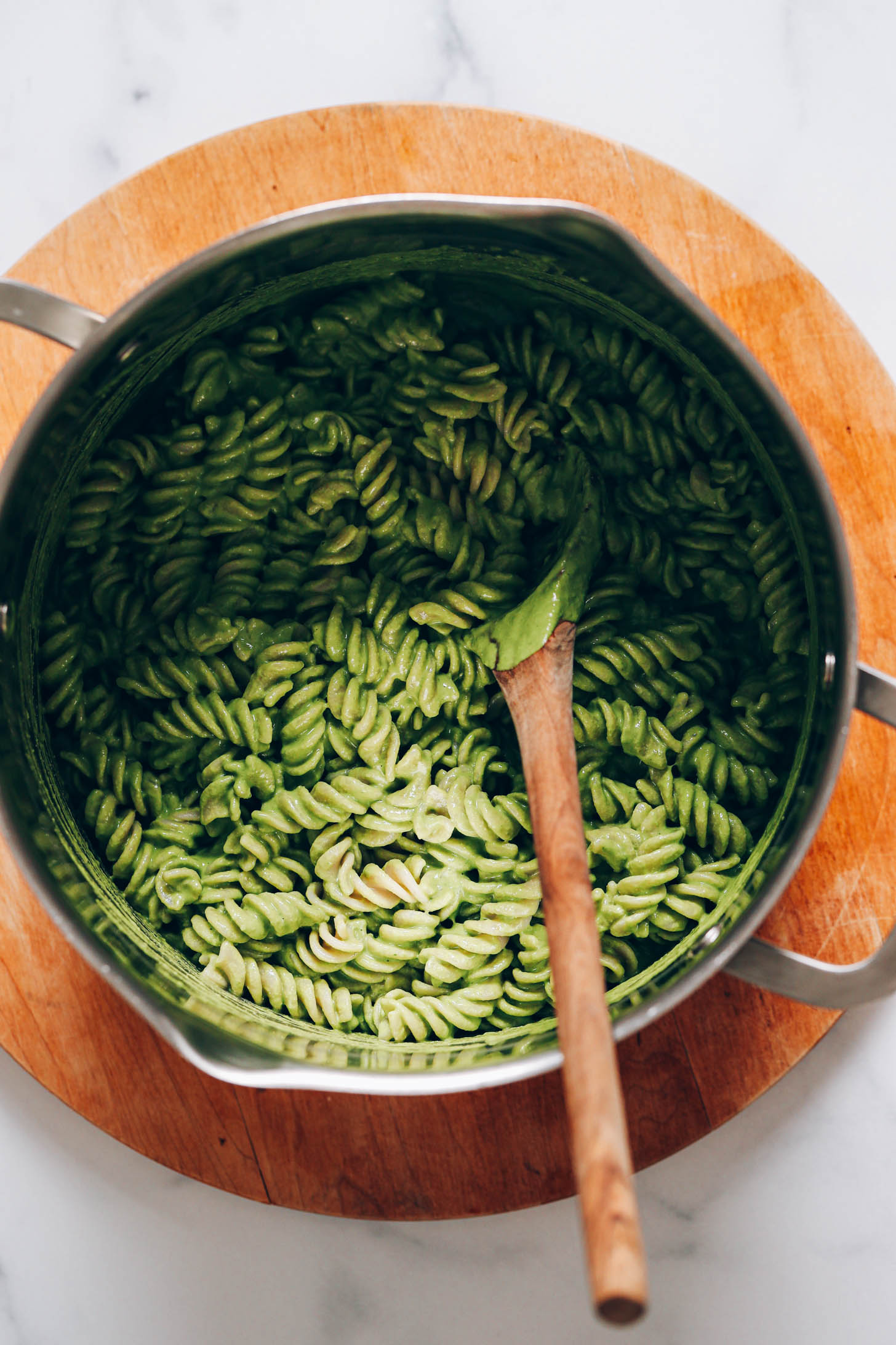 Pot of noodles coated in a green cashew pesto sauce