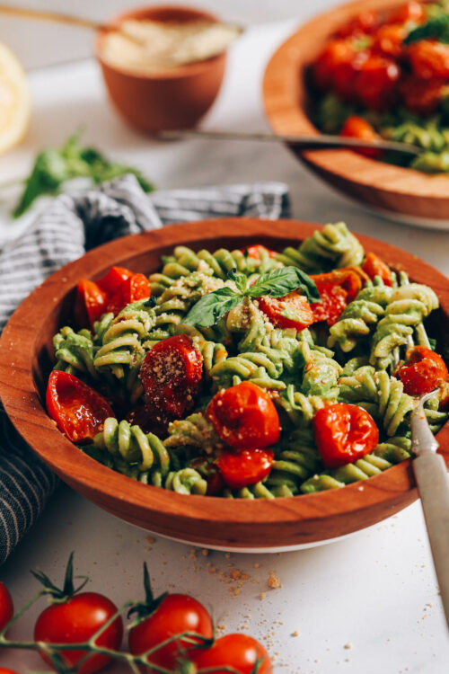 Bowl of creamy vegan pesto pasta with roasted cherry tomatoes