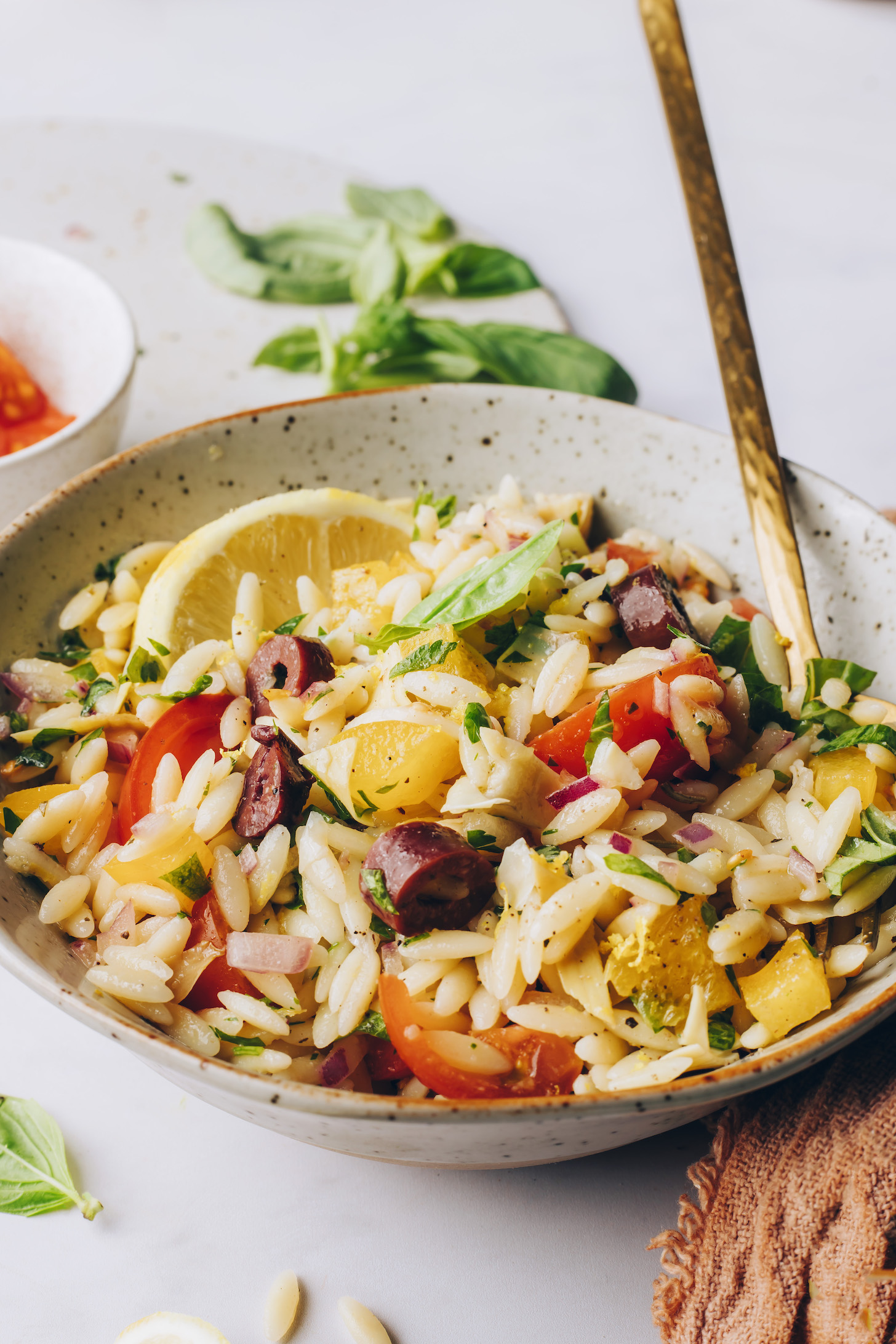 Bowl of orzo pasta salad with a lemon slice