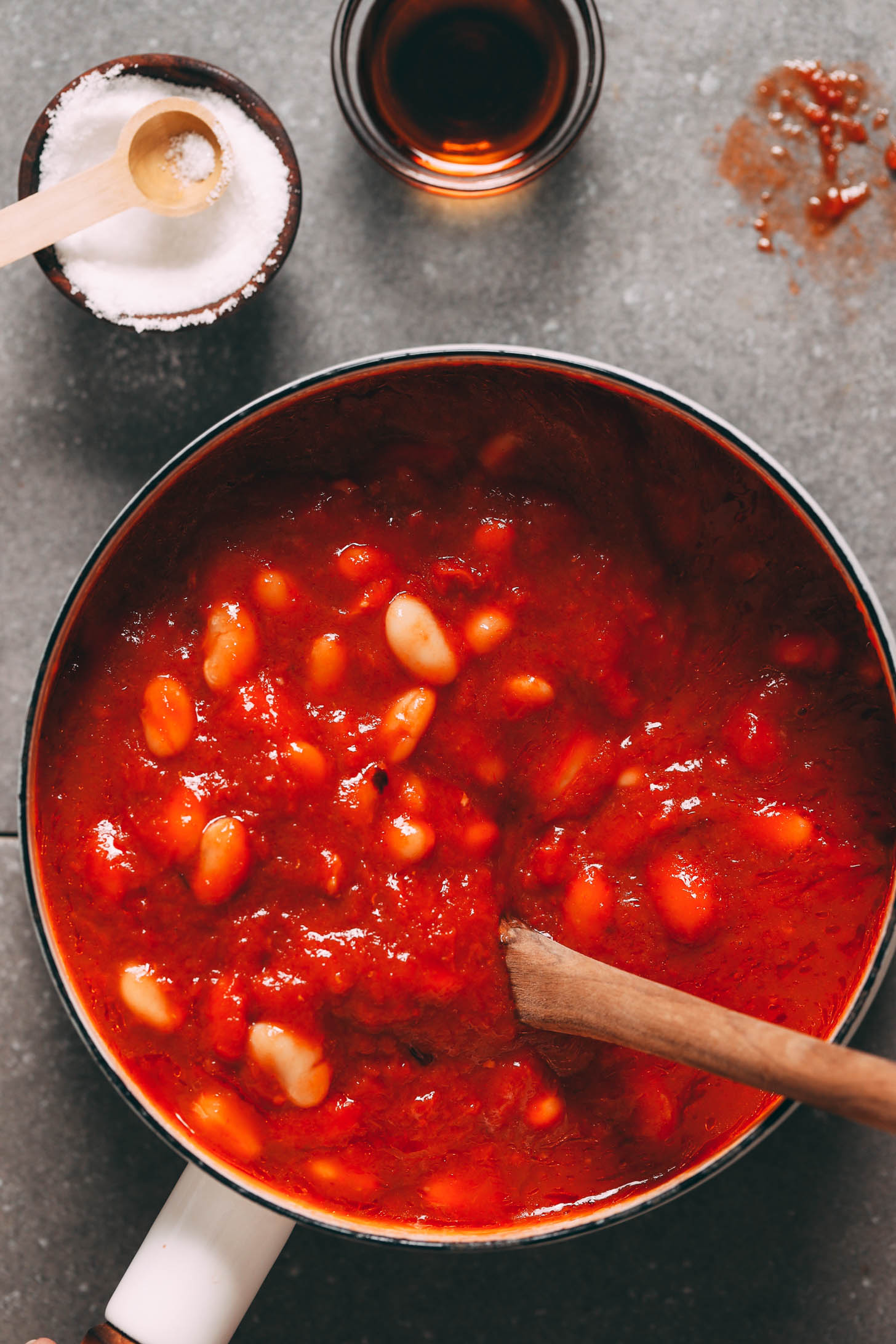 Maple syrup and salt next to a pot of white bean tomato soup
