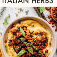 Bowl of polenta with crispy baked tofu with italian herbs on top
