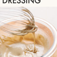 Whisk whisking a bowl of vegan and gluten-free tahini dressing