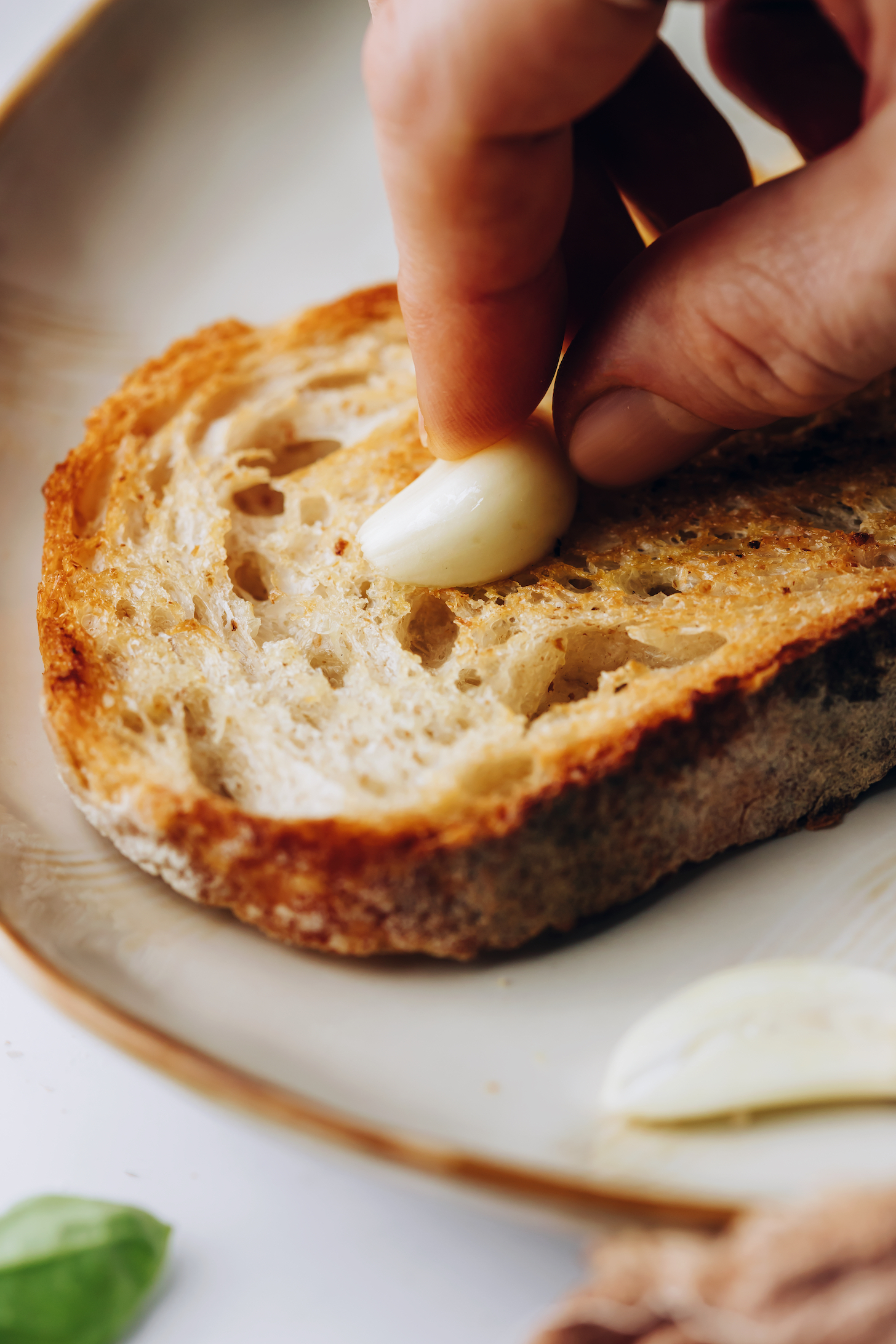 Rubbing a garlic clove on a slice of toasted bread