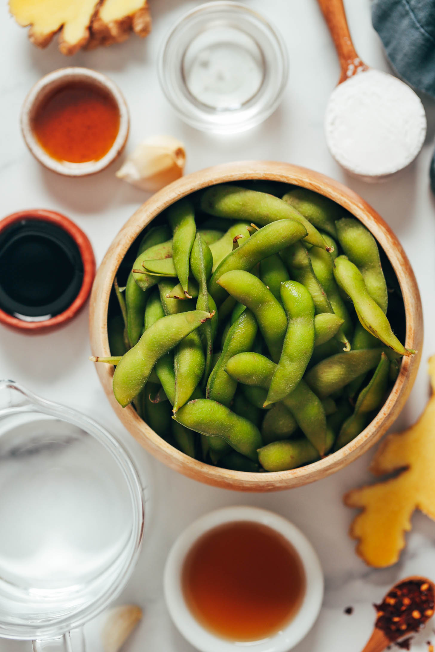 Edamame in their shells, red pepper flakes, ginger, tamari, maple syrup, arrowroot starch, garlic, water, and coconut oil