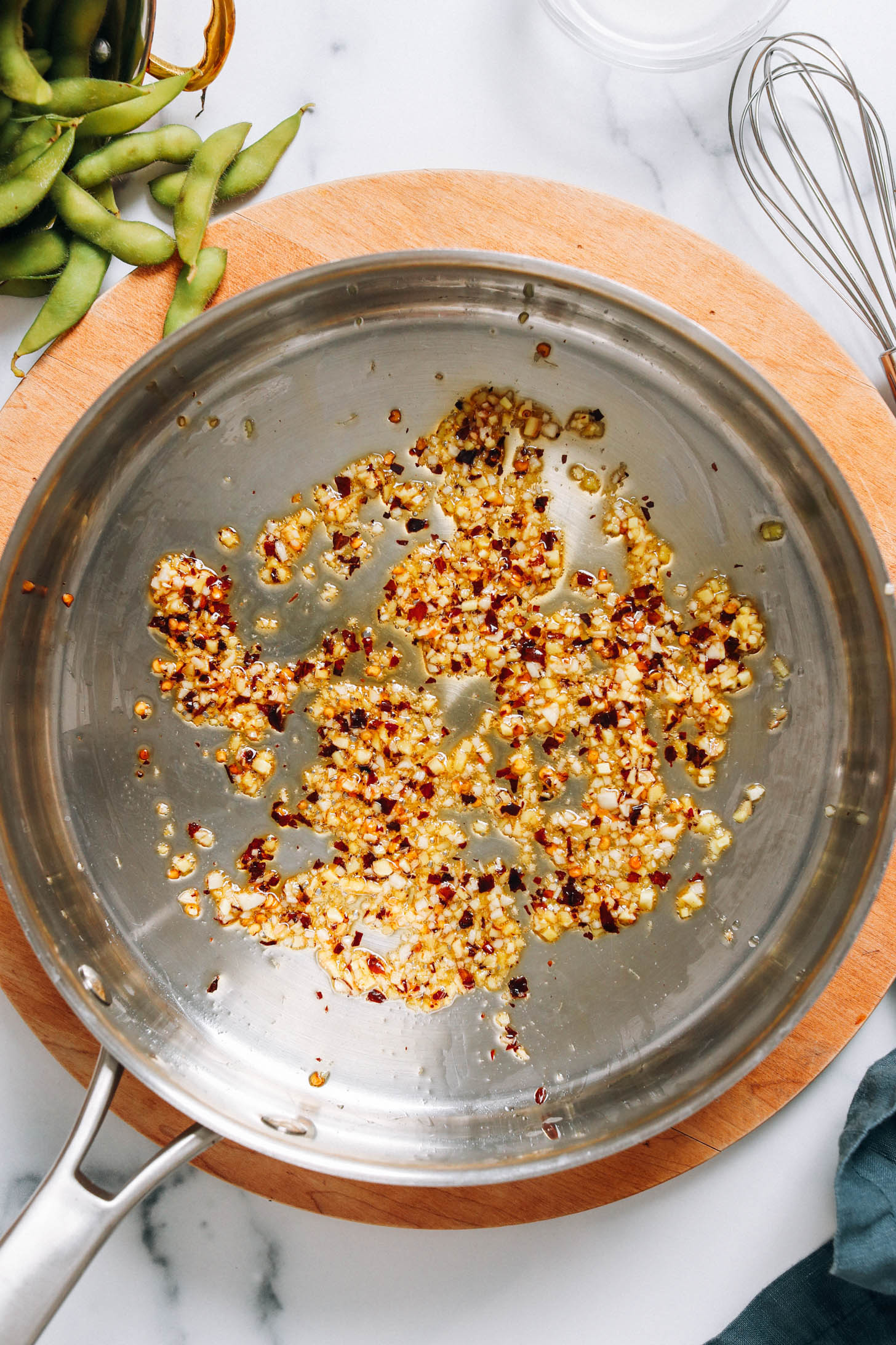 Sautéing garlic, ginger, and red pepper flakes in coconut oil