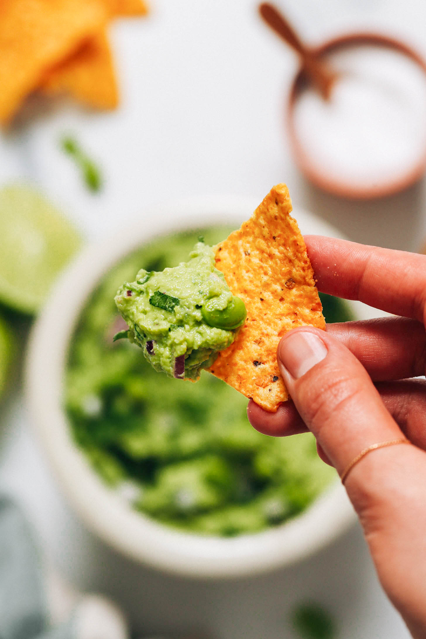 Close up shot of a tortilla chip with edamame guacamole