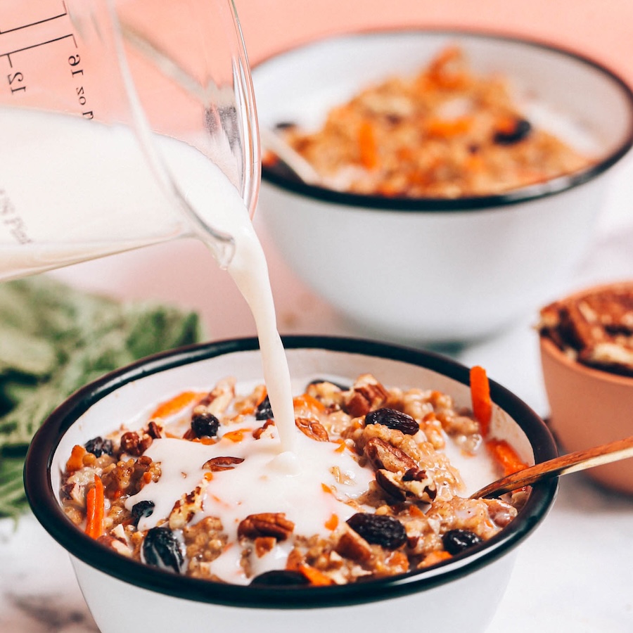 Pouring dairy-free milk into a bowl of Carrot Cake Oatmeal made in the Instant Pot