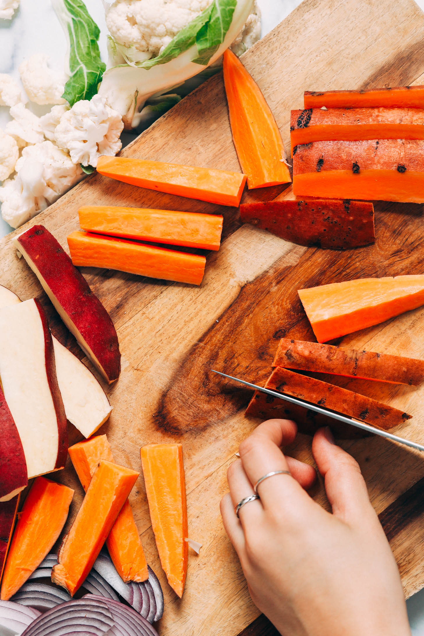 Slicing sweet potatoes into wedges