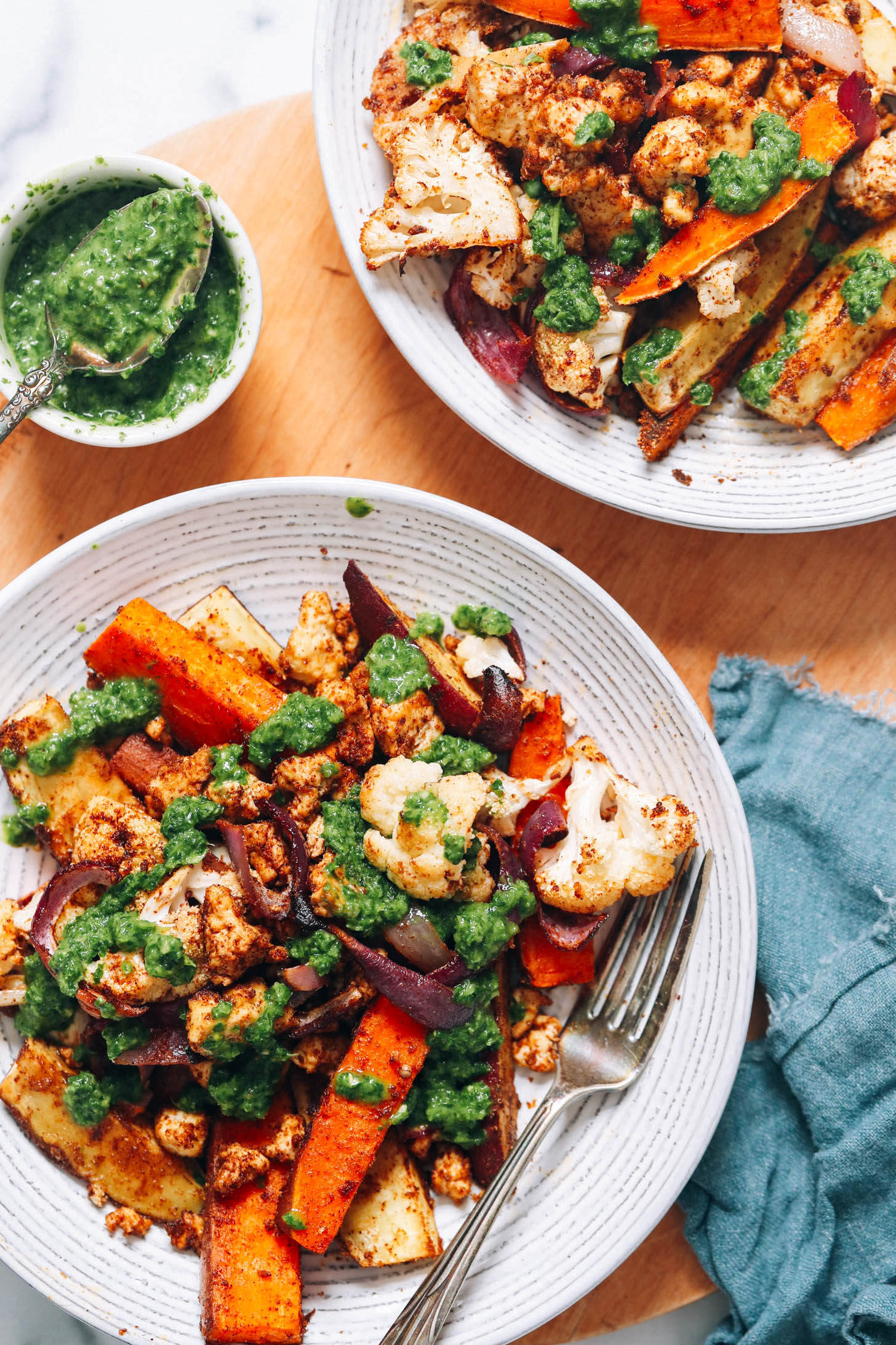 Two large bowls of our tandoori masala sheet pan dinner topped with green chutney
