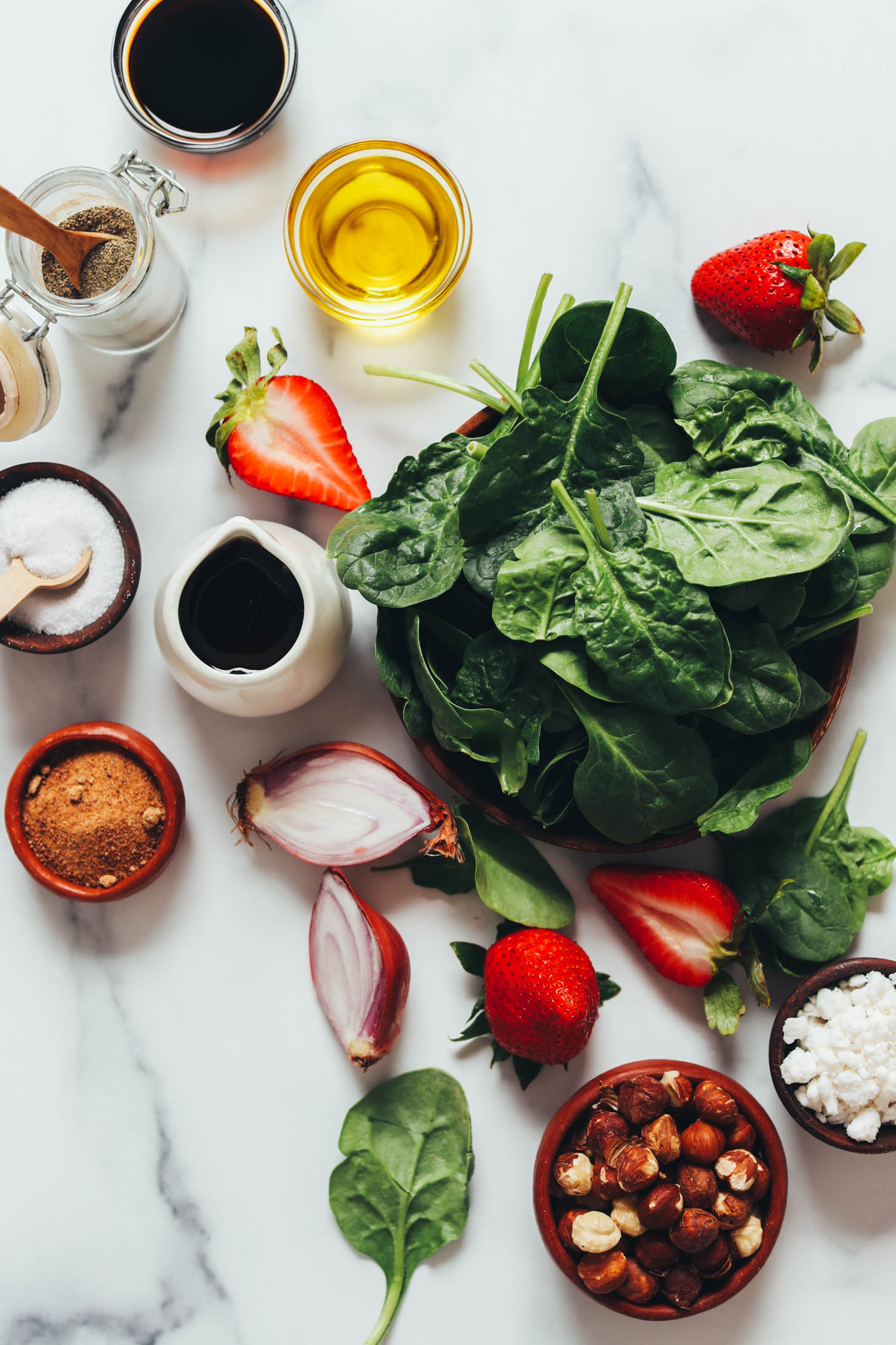 Balsamic vinegar, olive oil, salt, black pepper, maple syrup, coconut sugar, shallot, strawberries, spinach, hazelnuts, and vegan feta cheese