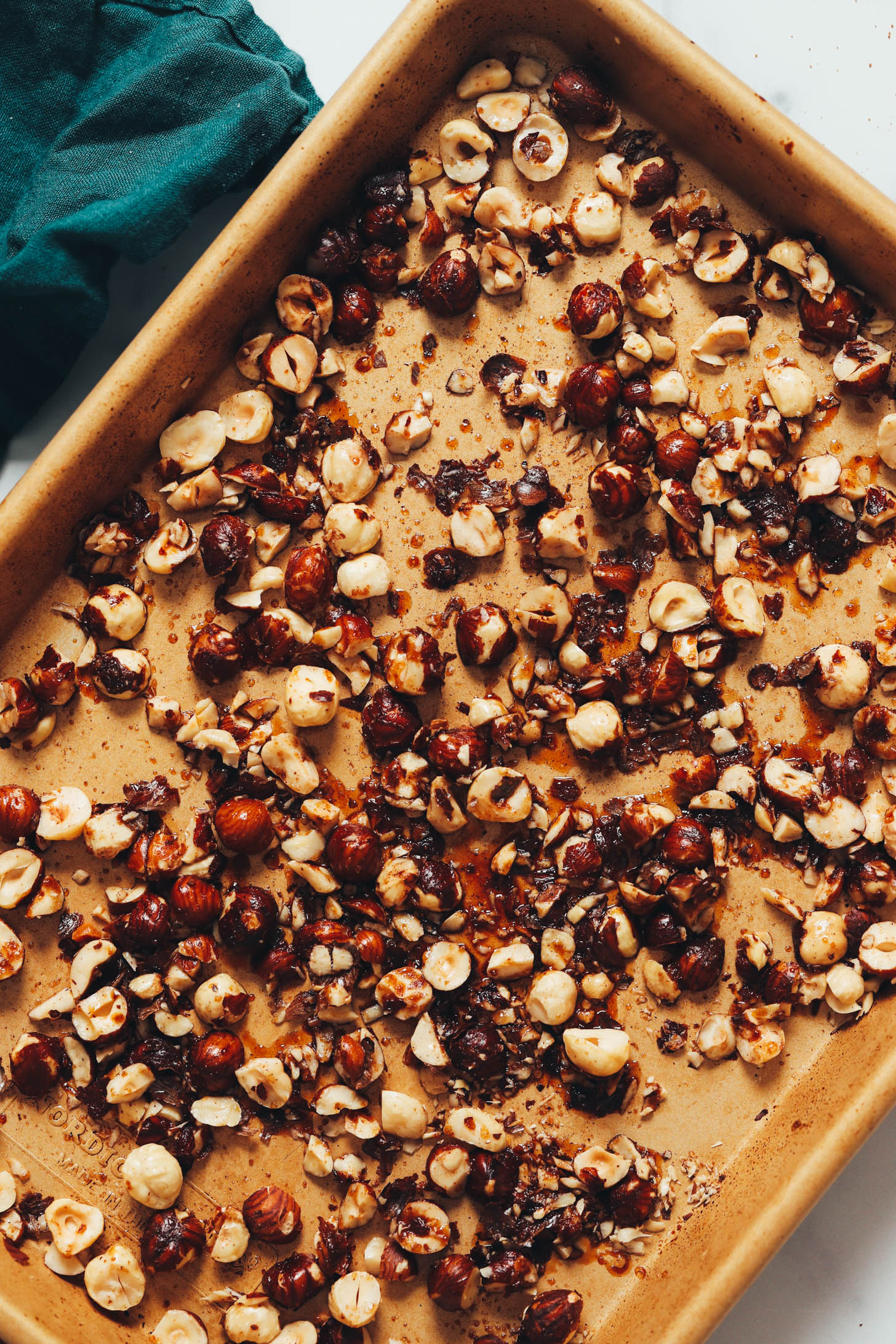 Candied hazelnuts on a gold baking sheet
