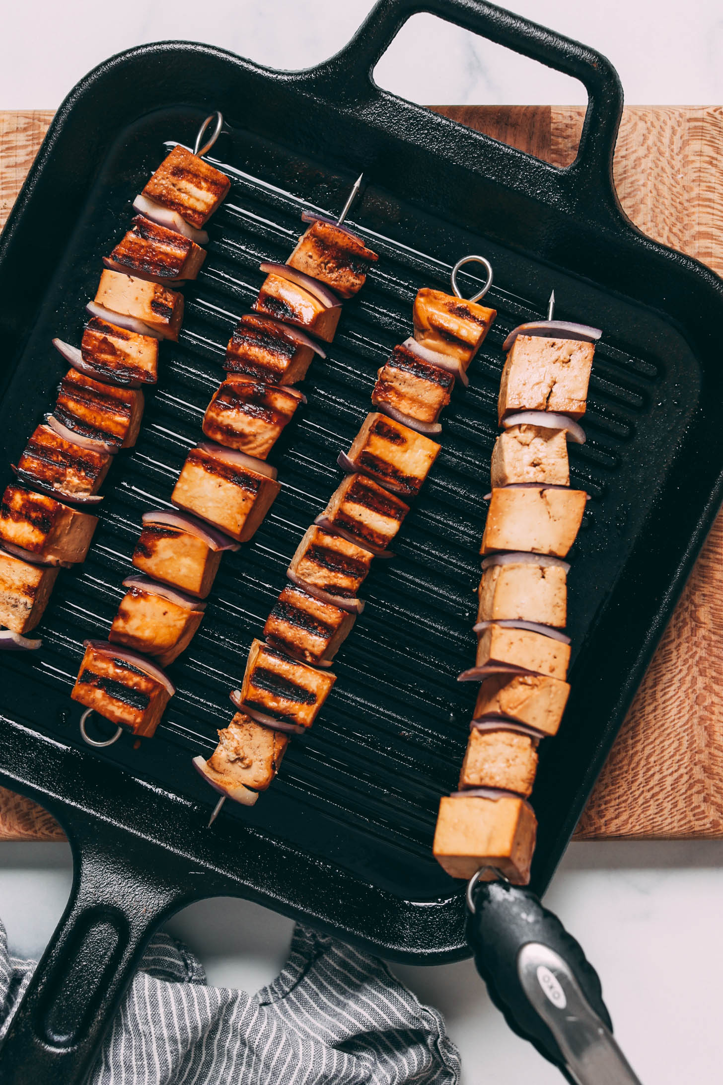Tofu skewers cooking on a grill pan