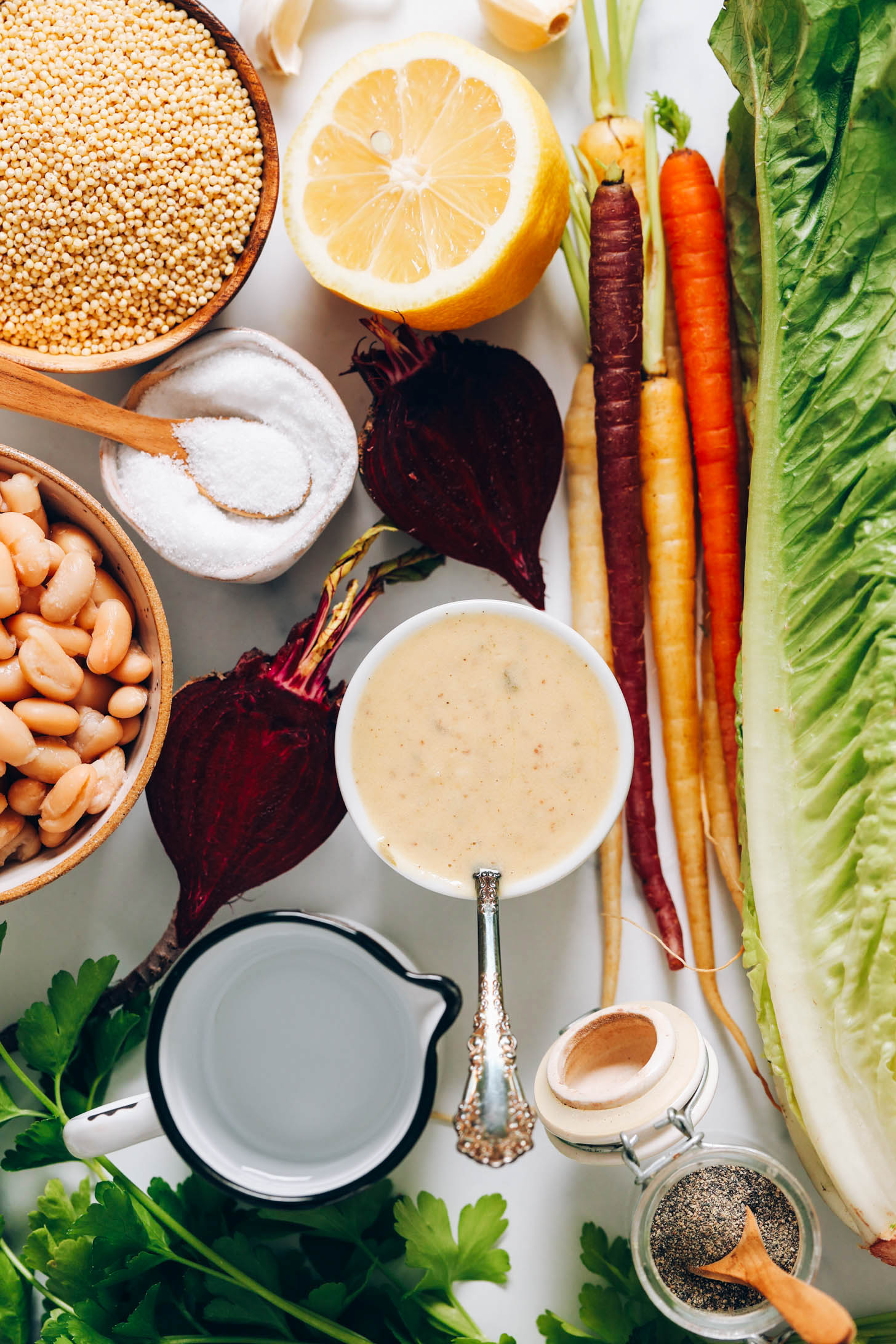 Millet, garlic, lemon, rainbow carrots, romaine lettuce, black pepper, parsley, caesar dressing, beets, white beans, and salt