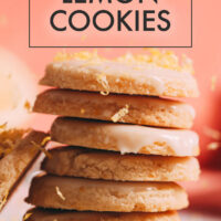 Stack of easy vegan and gluten-free lemon cookies with frosting and lemon zest on top