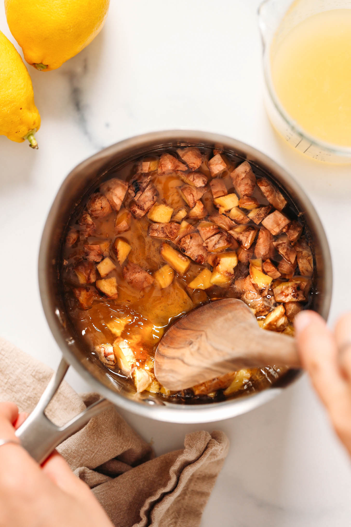 Simmering fresh ginger with agave and water to make a naturally sweetened ginger simple syrup