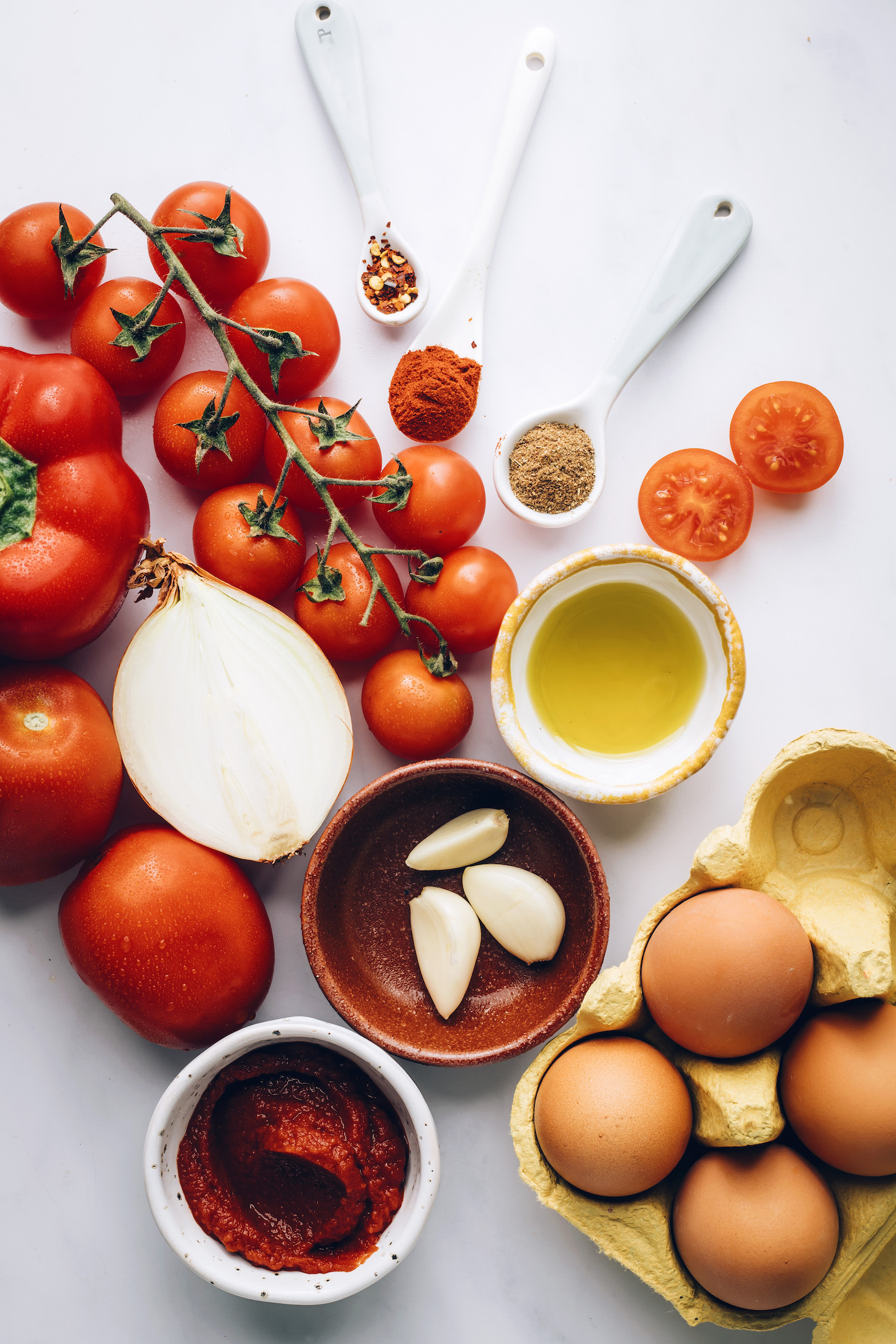 Cherry and roma tomatoes, onion, red bell pepper, tomato paste, eggs, garlic, olive oil, black pepper, paprika, and red pepper flakes