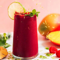 Lime zest falling onto a glass of our mango beet smoothie recipe