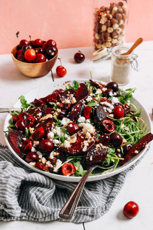 Cherries and hazelnuts beside a bowl of our roasted beet and cherry salad