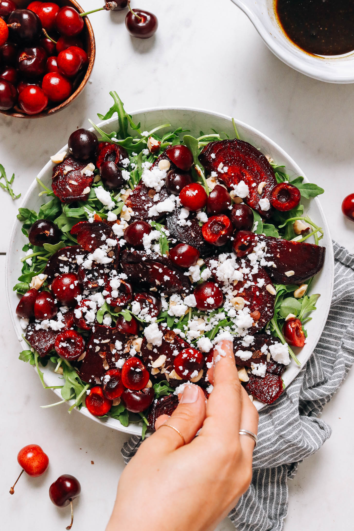 Sprinkling vegan feta crumbles onto a salad