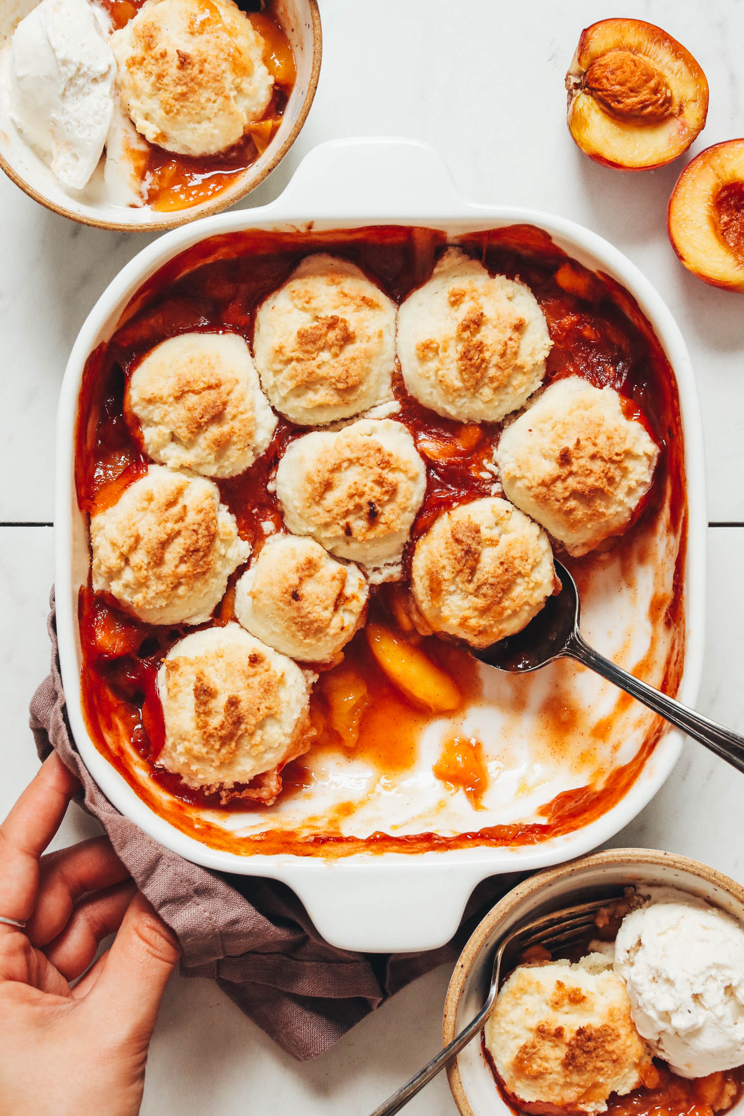 Bowls and baking dish of gluten-free peach cobbler