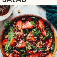 Bowl of vegan and gluten-free strawberry spinach salad with candied hazelnuts