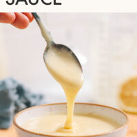 Spoon scooping easy vegan hollandaise sauce out of a ramekin