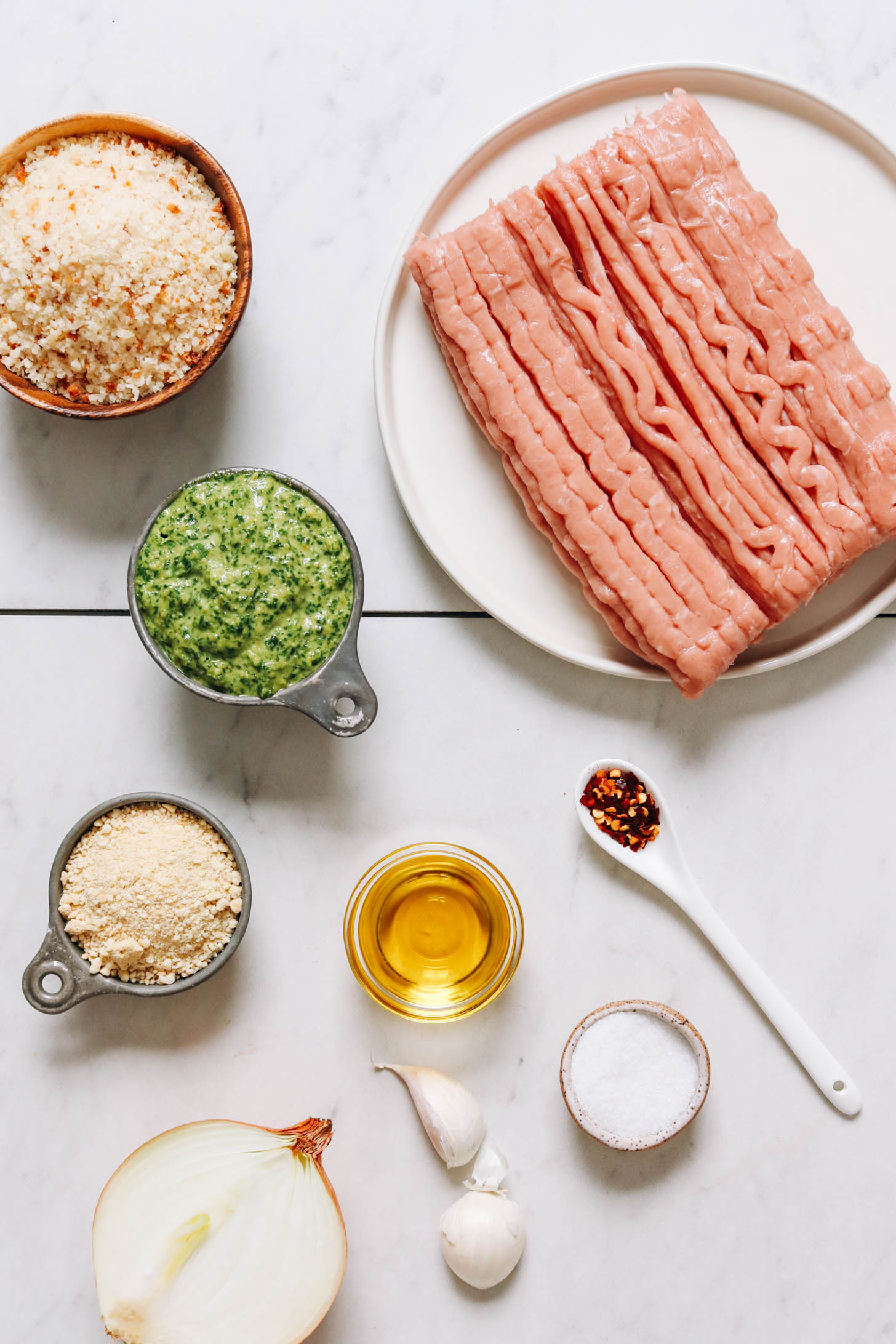 Breadcrumbs, basil pesto, dairy-free parmesan, onion, garlic, salt, oil, red pepper flakes, and ground turkey