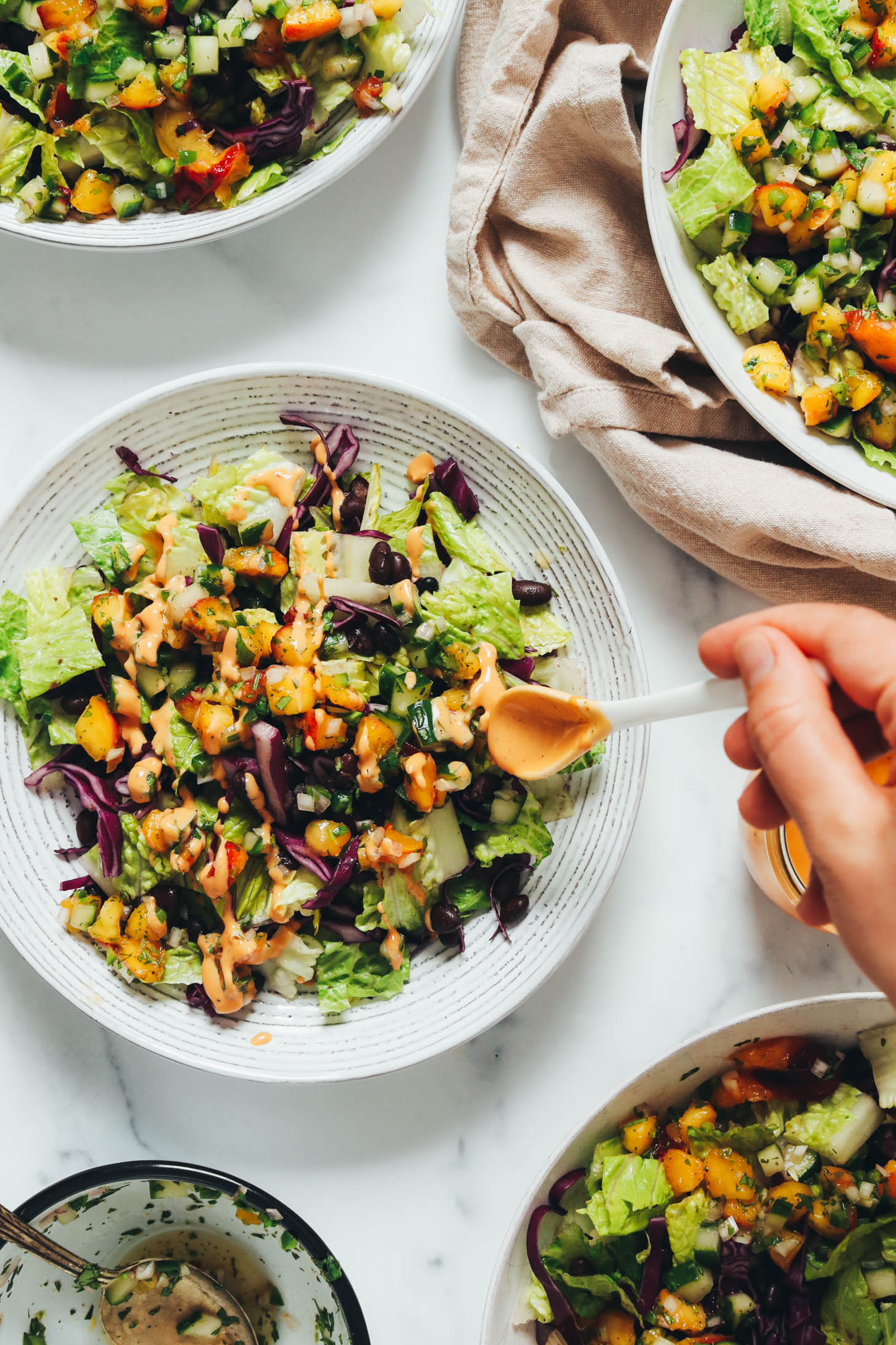 Adding dairy-free chipotle lime dressing to a salad