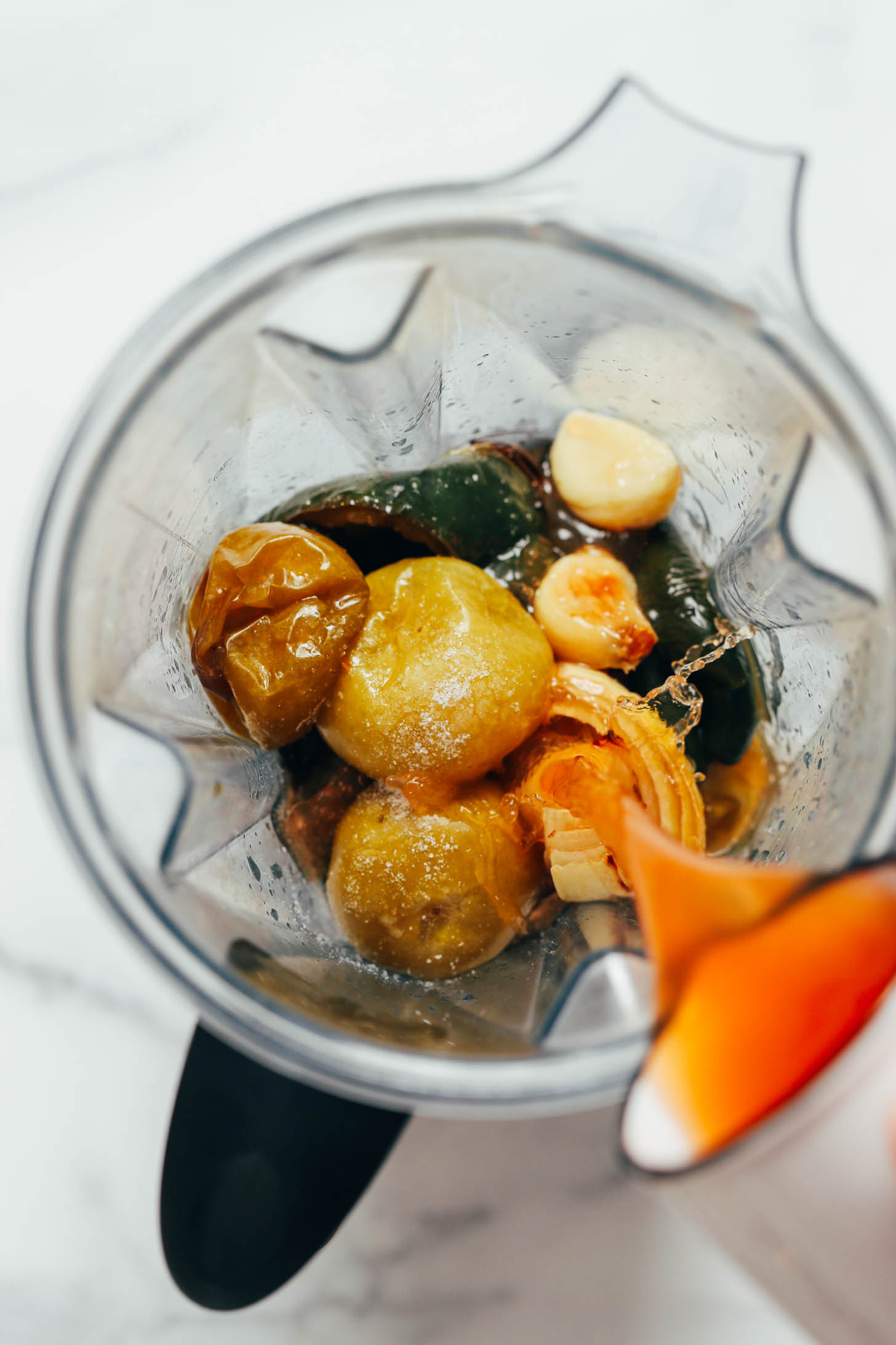 Pouring vegetable broth over roasted vegetables