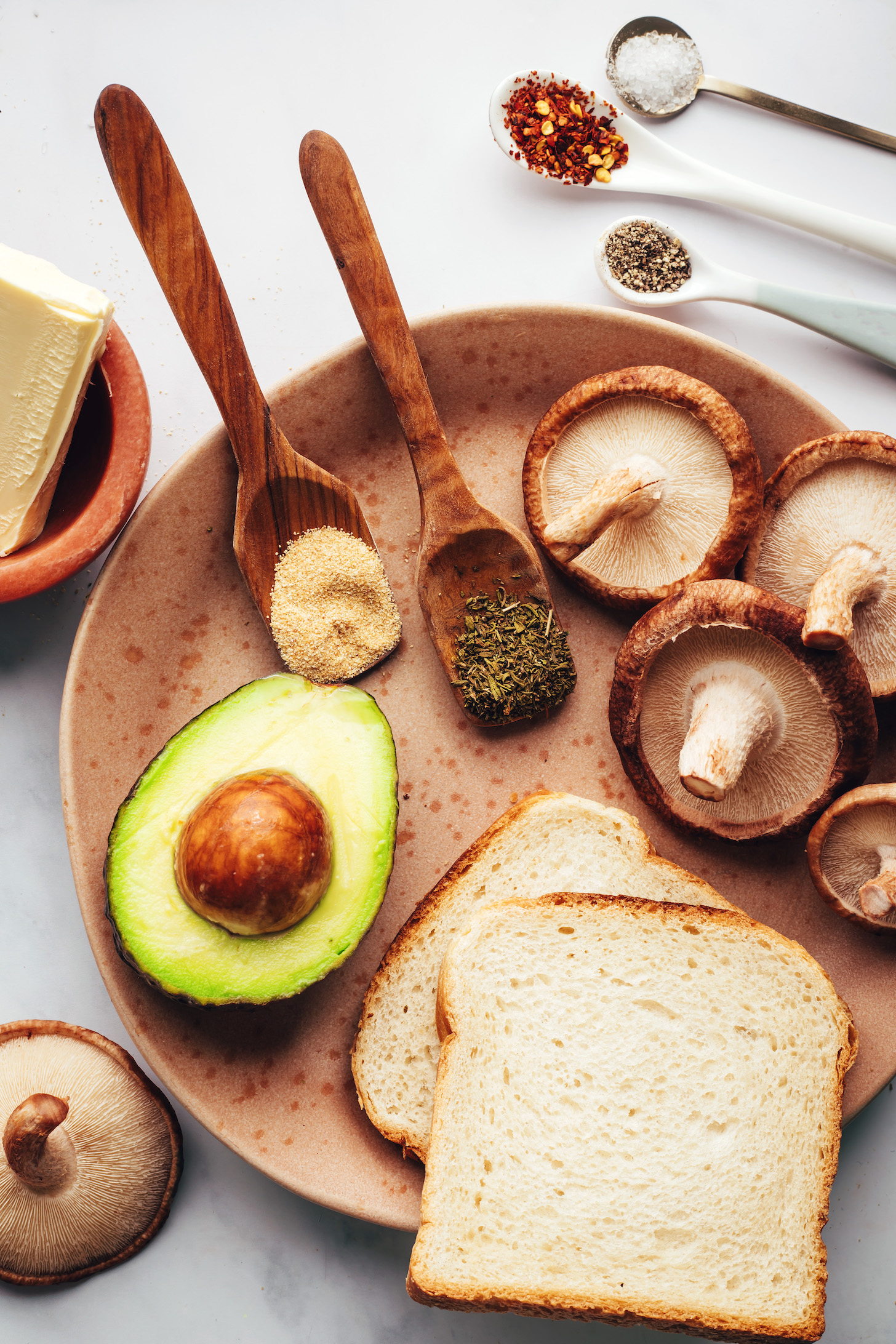 Shiitake mushrooms, bread, avocado, dried thyme, garlic powder, vegan butter, salt, red pepper flakes, and black pepper