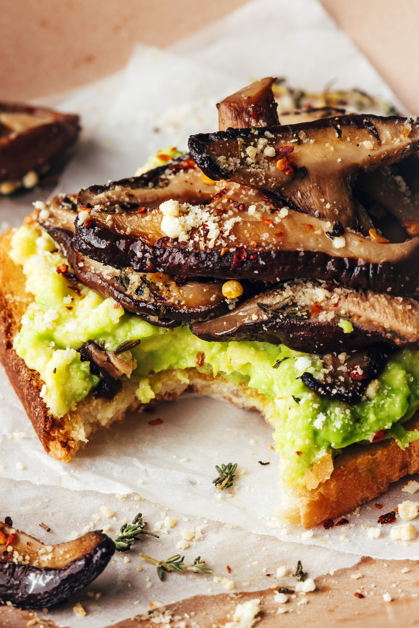 Slice of mushroom avocado toast with a bite taken out