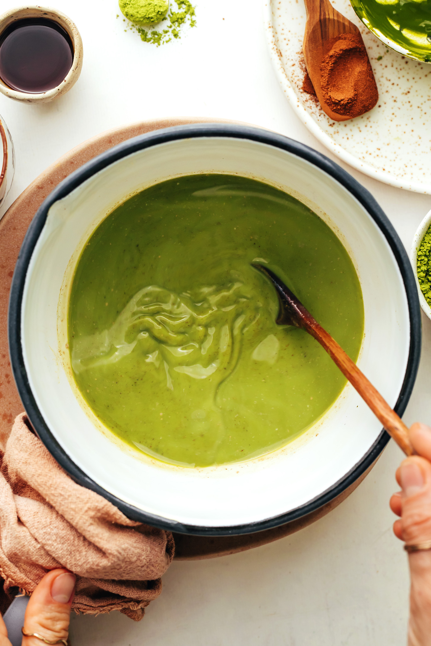 Stirring dissolved matcha powder into warm dairy-free milk