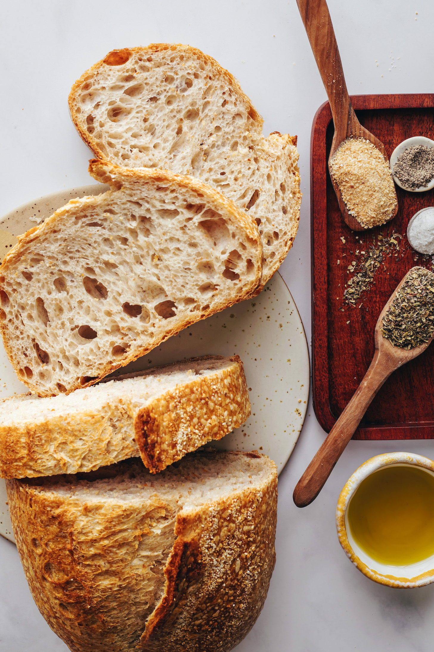 Sliced sourdough bread, garlic powder, salt, pepper, Italian herbs, and oil