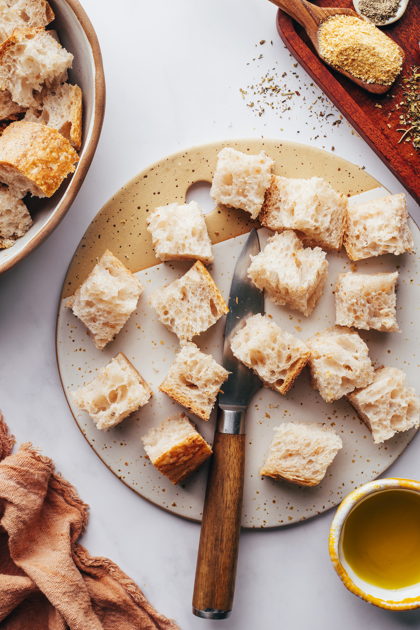 Knife on a cutting board with cubed bread