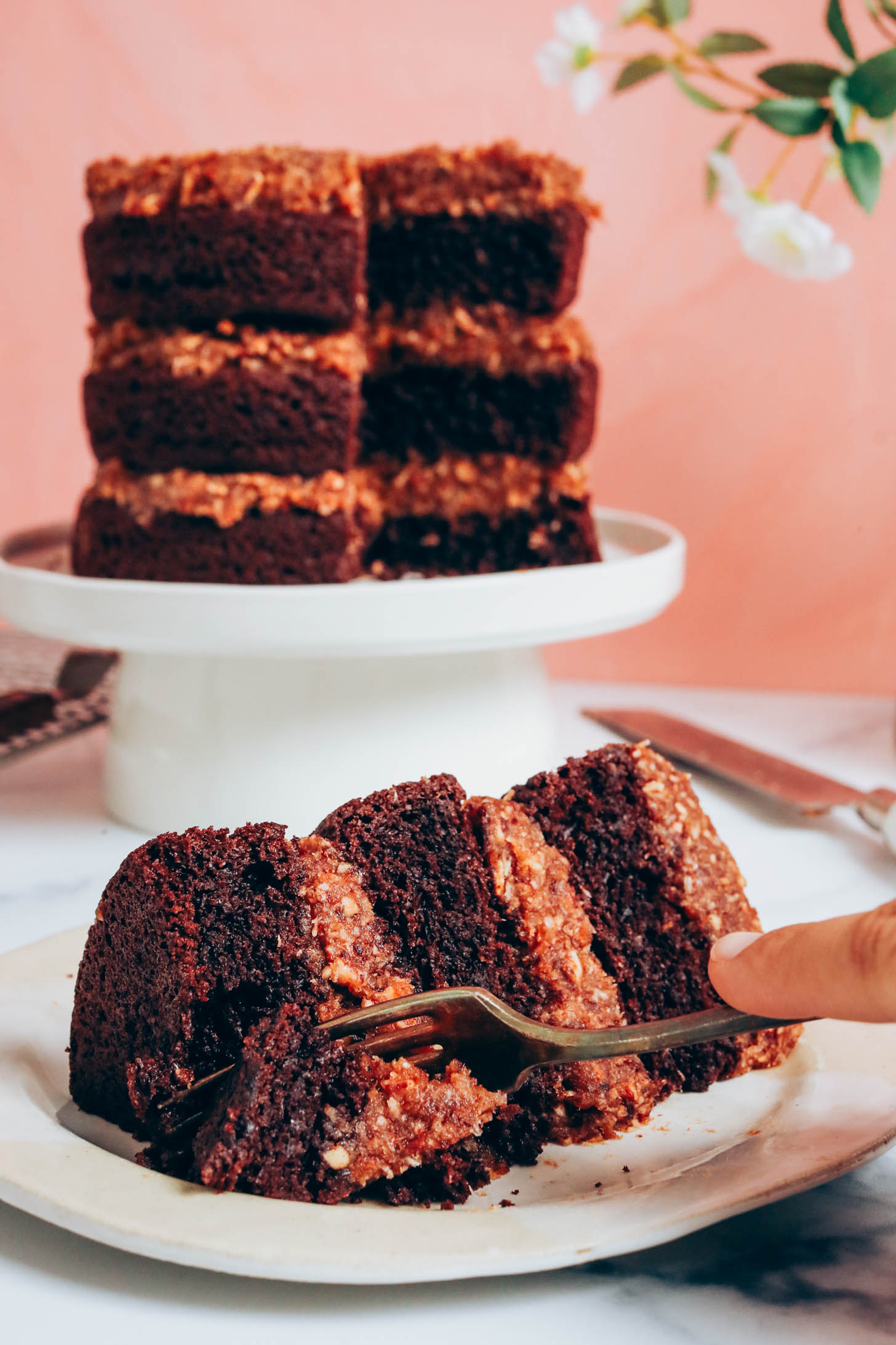 Fork cutting into a slice of vegan gluten-free German chocolate cake