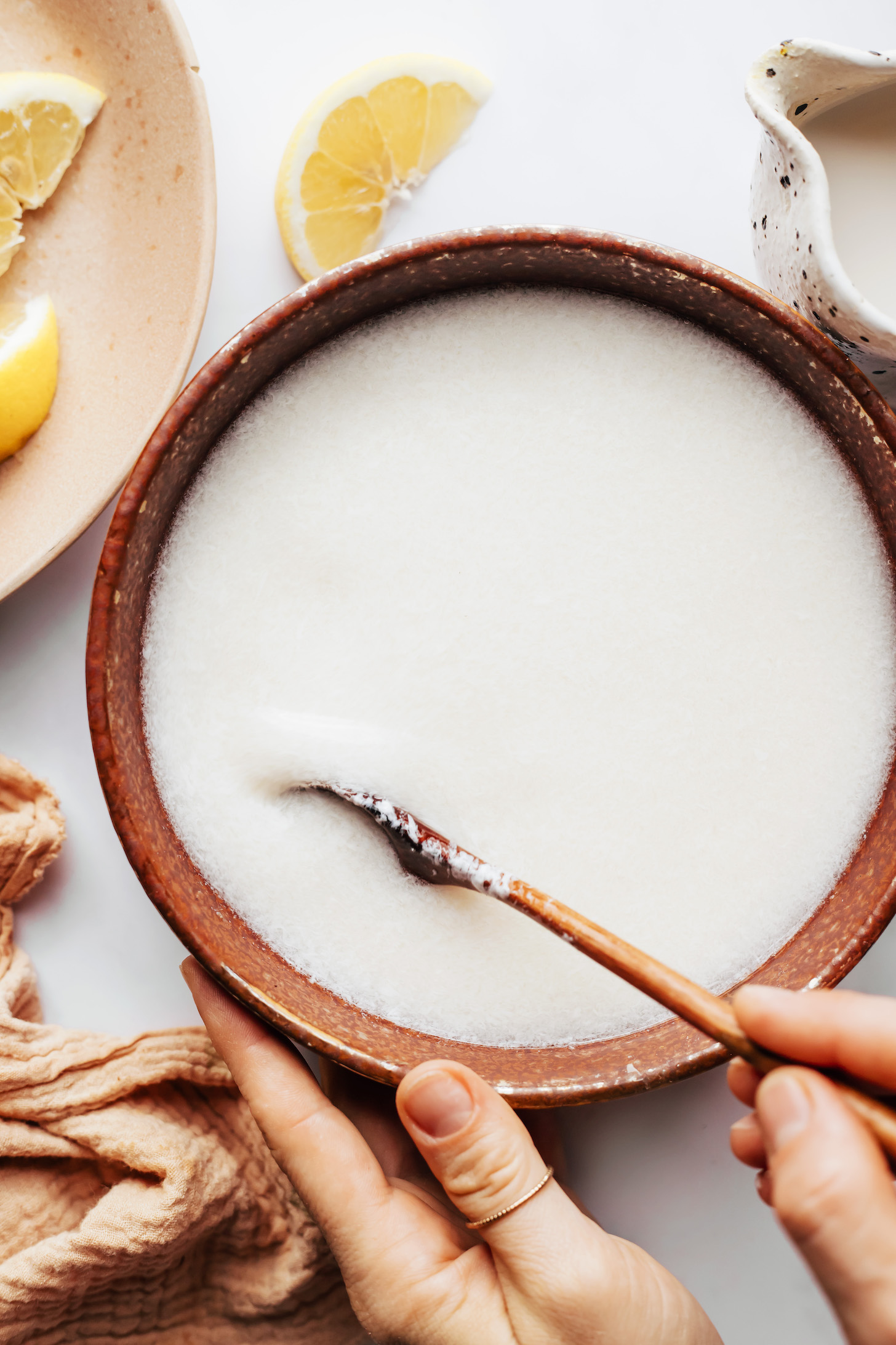 Stirring together almond milk and lemon juice in a bowl