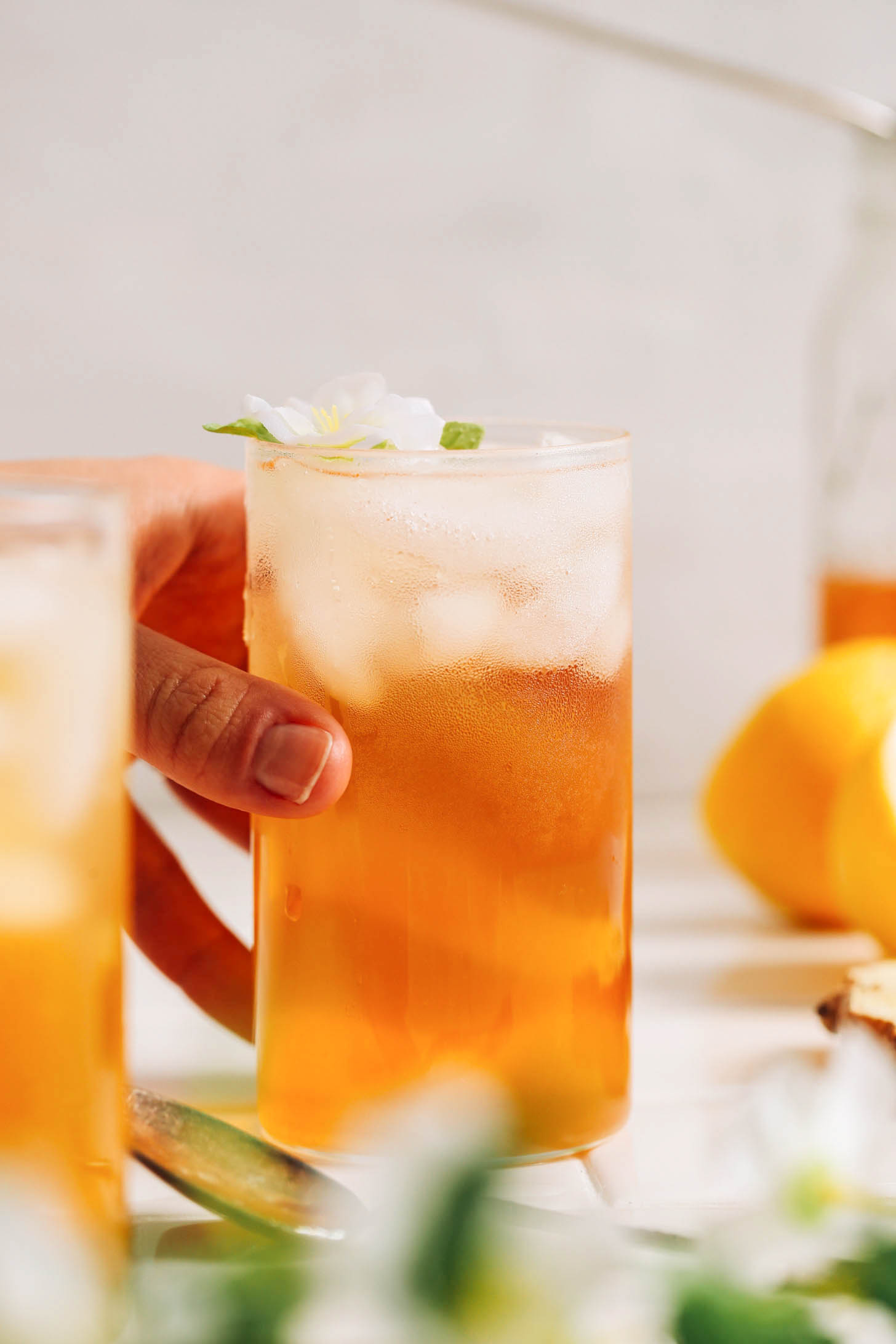 Hand reaching in to pick up a glass of iced tea