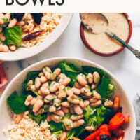 Vegan and gluten-free hearty white bean caesar salad bowl with caesar salad dressing on the side