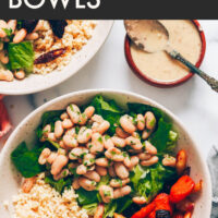 Vegan and gluten-free hearty white bean caesar salad bowl with caesar salad dressing on the side