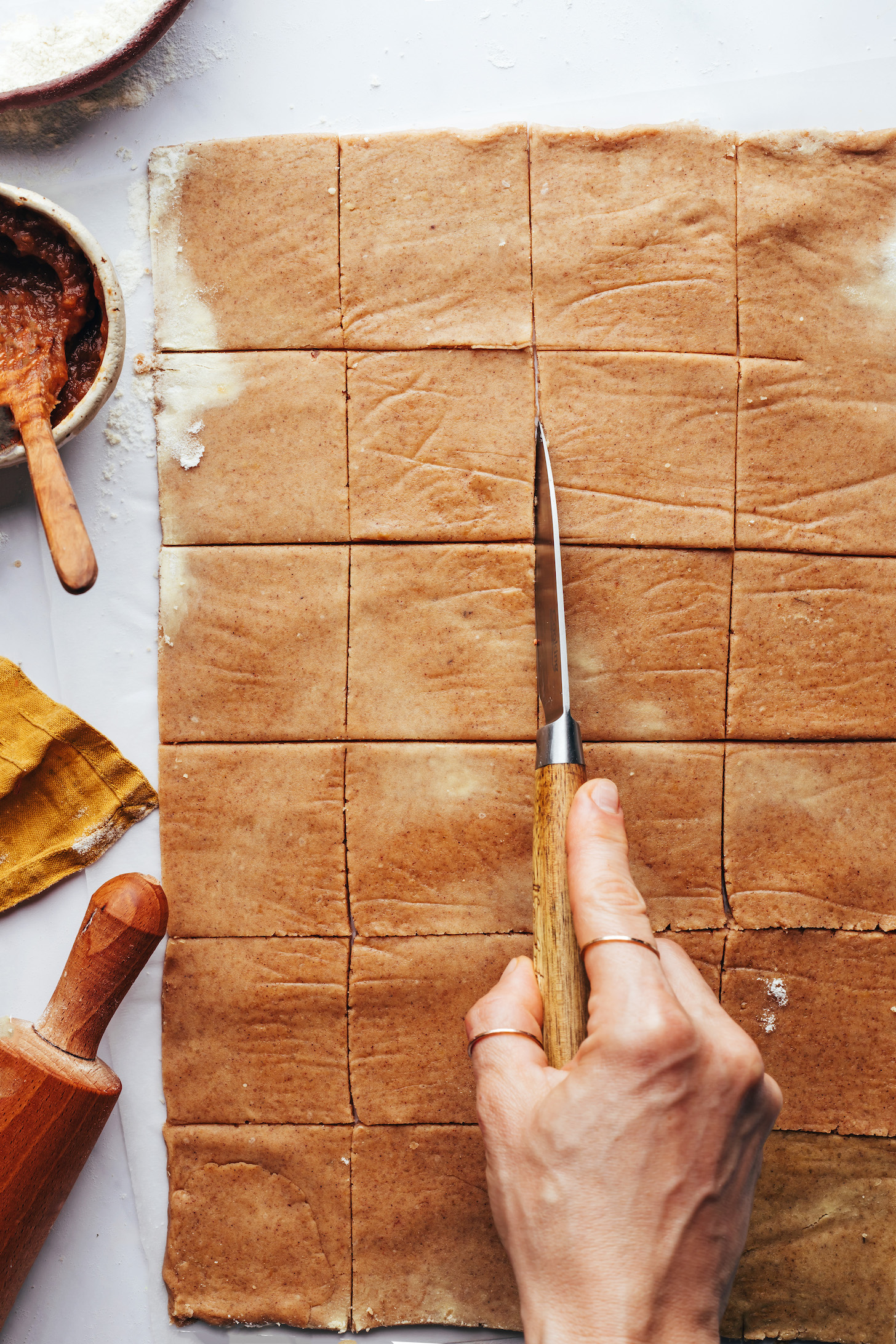 Using a knife to cut dough into squares